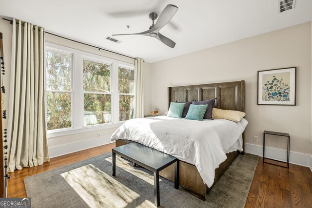 bedroom featuring multiple windows, ceiling fan, and dark hardwood / wood-style flooring