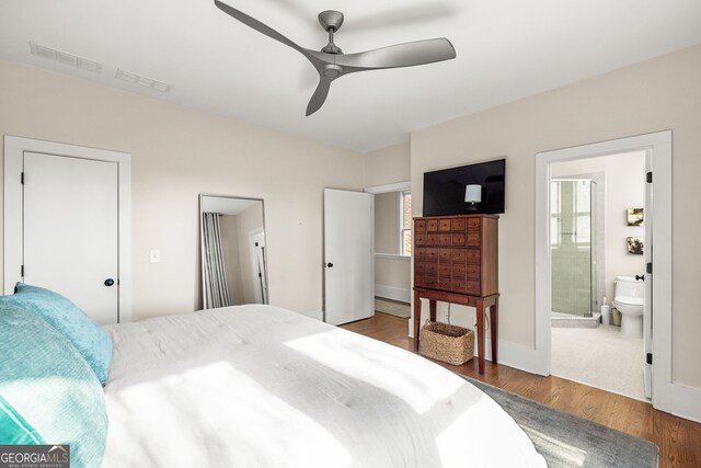 bedroom with ceiling fan, dark hardwood / wood-style flooring, and ensuite bath