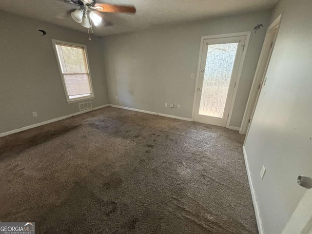 carpeted spare room featuring ceiling fan and a textured ceiling