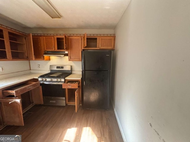 kitchen with gas stove, black fridge, and dark wood-type flooring