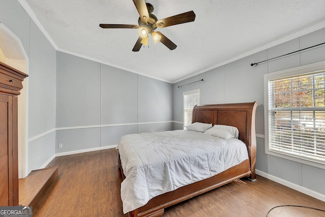 bedroom with multiple windows, ceiling fan, dark hardwood / wood-style flooring, and a textured ceiling