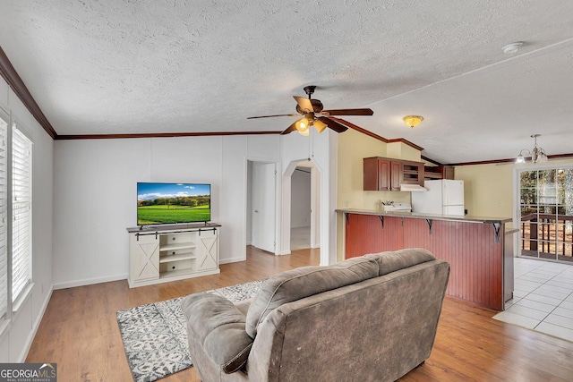 living room featuring light hardwood / wood-style floors, a textured ceiling, and vaulted ceiling