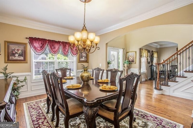 dining room with crown molding, hardwood / wood-style floors, and a notable chandelier