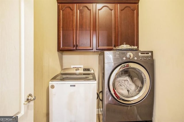 washroom with separate washer and dryer and cabinets