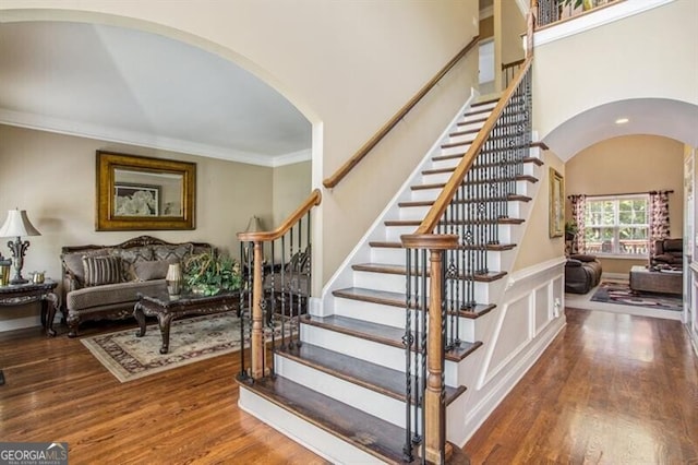 stairway with crown molding and hardwood / wood-style floors