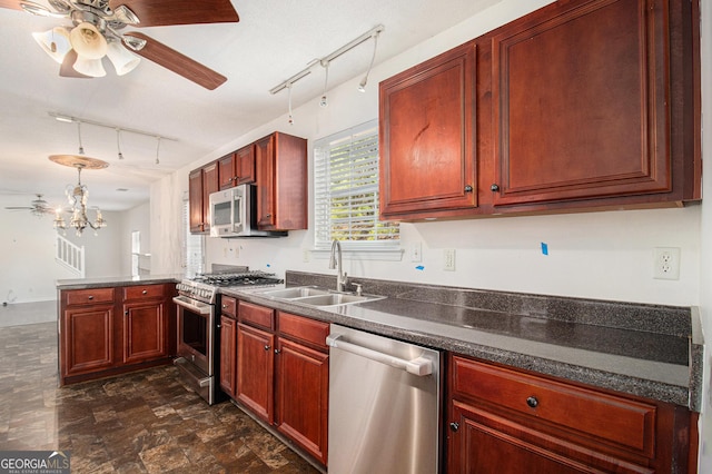 kitchen with a peninsula, a sink, dark brown cabinets, appliances with stainless steel finishes, and dark countertops