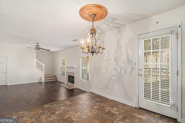 unfurnished living room with stairway, a fireplace, wood finished floors, and baseboards