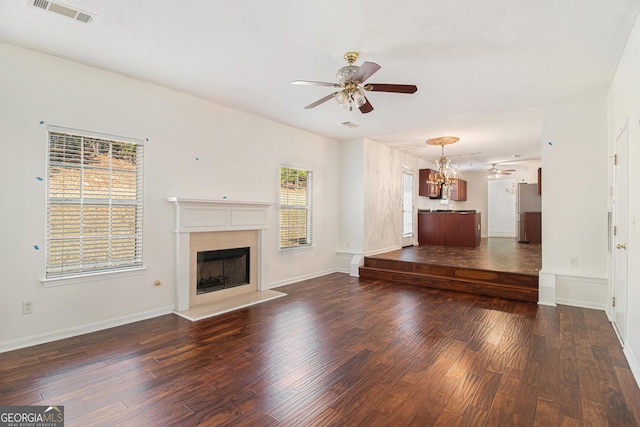 unfurnished living room featuring visible vents, a premium fireplace, ceiling fan, wood finished floors, and baseboards