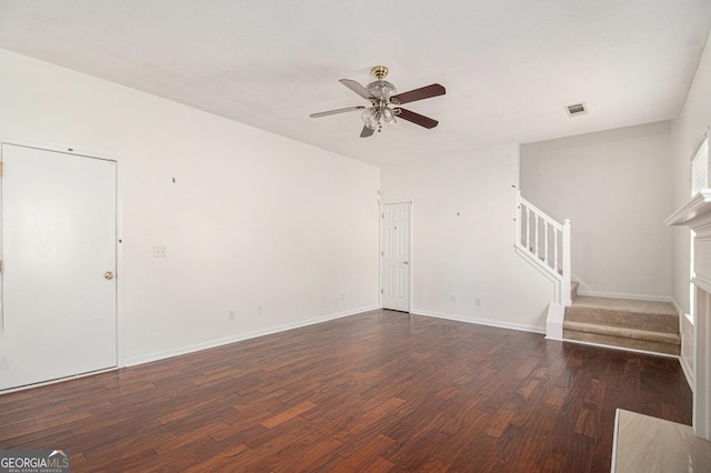 unfurnished living room featuring visible vents, a ceiling fan, wood finished floors, baseboards, and stairs