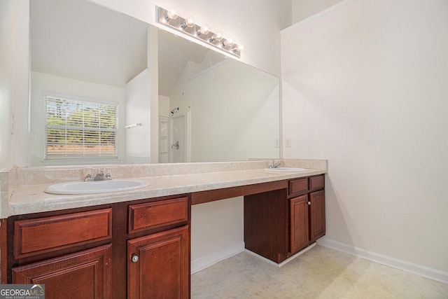 bathroom with walk in shower, a sink, baseboards, and double vanity