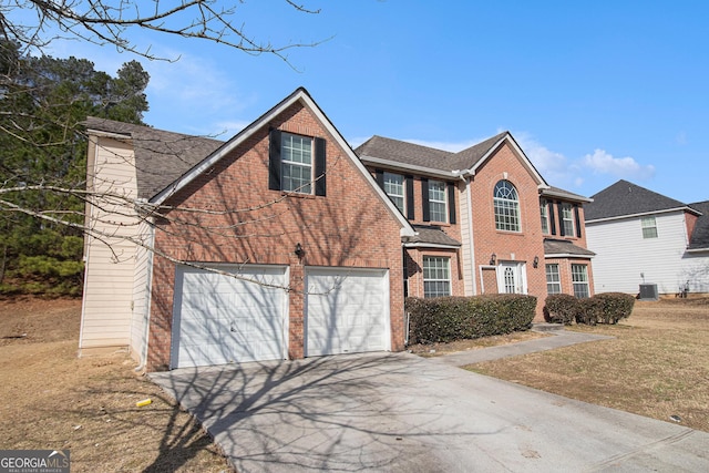 view of front facade with aphalt driveway, central AC unit, a garage, brick siding, and a chimney