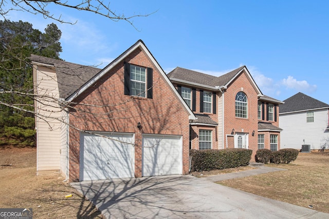 view of front of property featuring brick siding, a shingled roof, a garage, cooling unit, and driveway