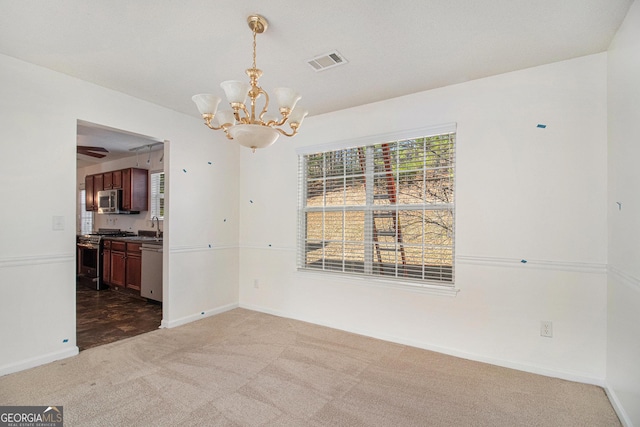 unfurnished dining area with an inviting chandelier, carpet, visible vents, and baseboards