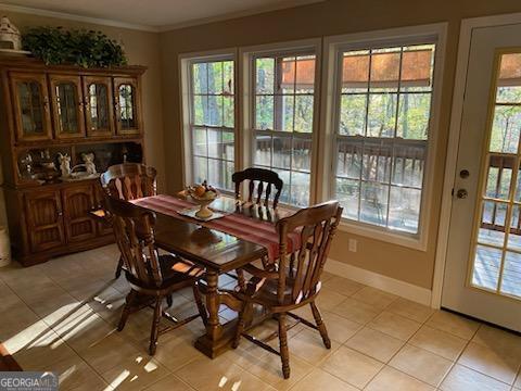 dining area featuring ornamental molding and light tile patterned floors