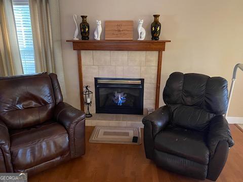 sitting room with hardwood / wood-style flooring and a tile fireplace