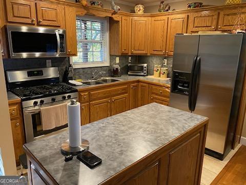 kitchen with appliances with stainless steel finishes, sink, backsplash, and light wood-type flooring