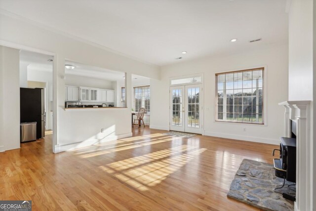 unfurnished living room with wood-type flooring, an inviting chandelier, and a wood stove