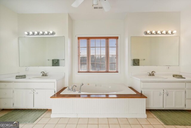 bathroom with tile patterned floors, a bathtub, vanity, ceiling fan, and toilet