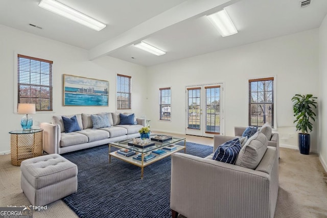 living room featuring light carpet, french doors, plenty of natural light, and beamed ceiling