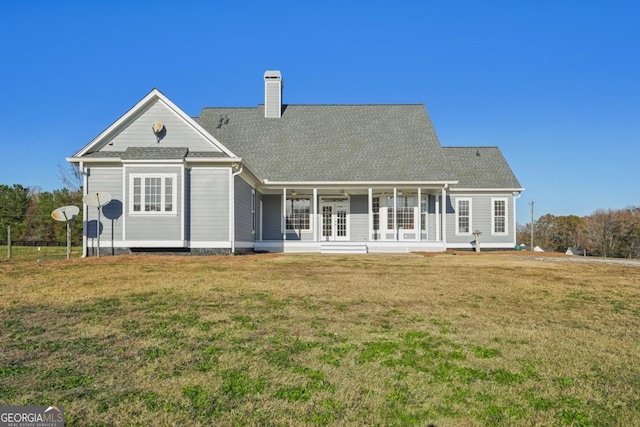 rear view of house with a porch and a lawn