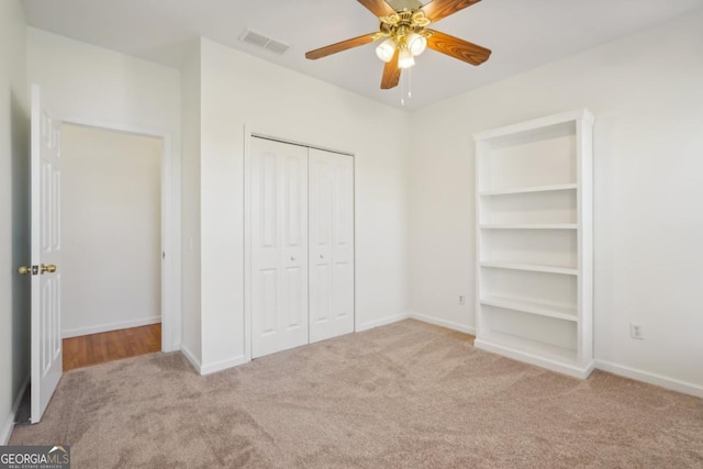 unfurnished bedroom with ceiling fan, a closet, and light colored carpet