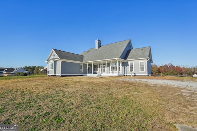 back of property featuring a yard and a porch