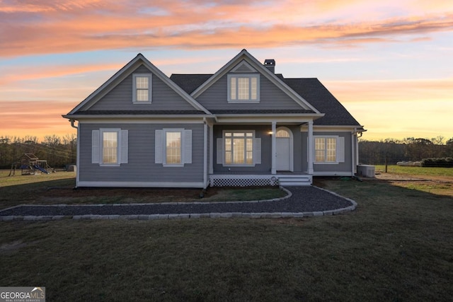 view of front of house with a yard and central AC