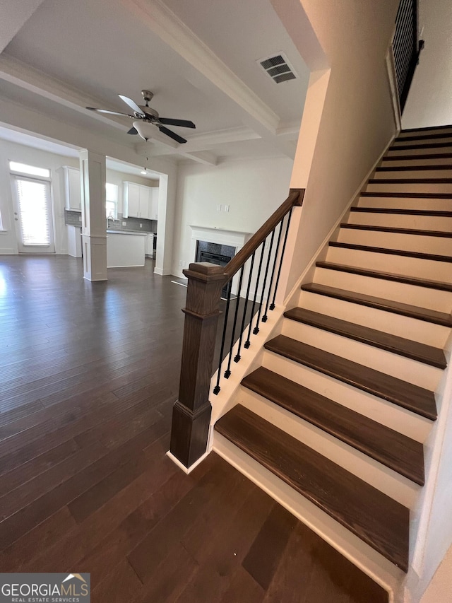 stairway featuring beamed ceiling, hardwood / wood-style floors, and ceiling fan