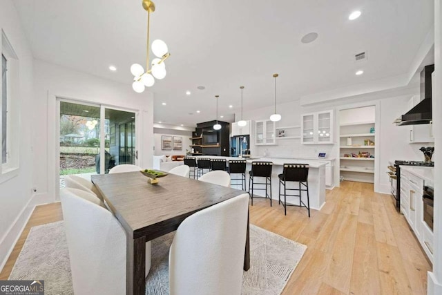 dining space with a chandelier and light hardwood / wood-style floors