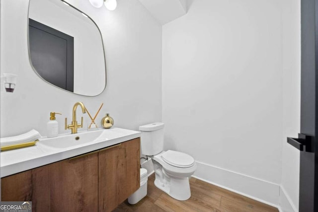 bathroom featuring vanity, hardwood / wood-style flooring, and toilet