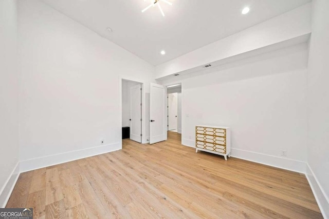 unfurnished bedroom featuring high vaulted ceiling and light wood-type flooring