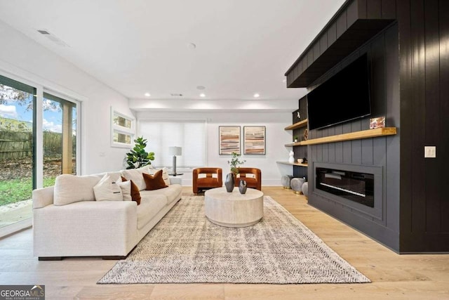 living room with a fireplace and light hardwood / wood-style flooring