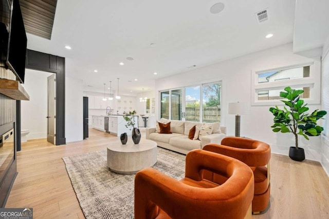 living room featuring sink and light wood-type flooring