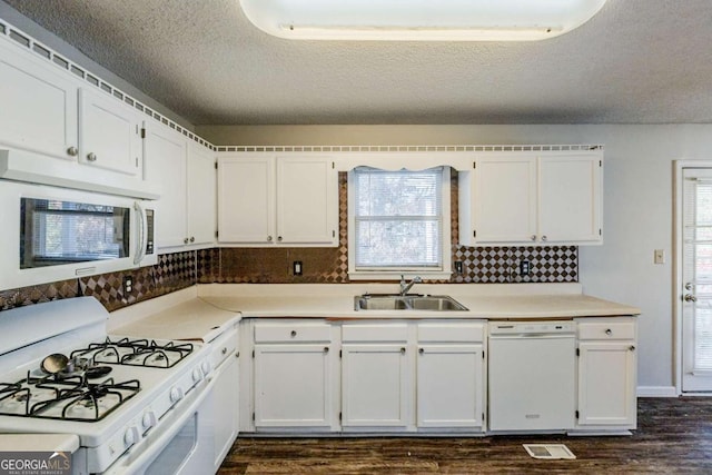 kitchen featuring white cabinets, white appliances, and sink