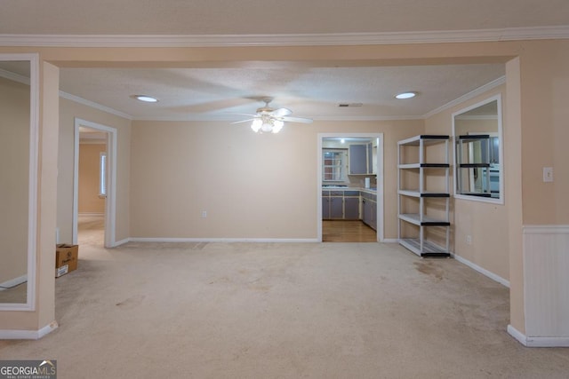 unfurnished living room featuring a textured ceiling, ceiling fan, crown molding, and light carpet