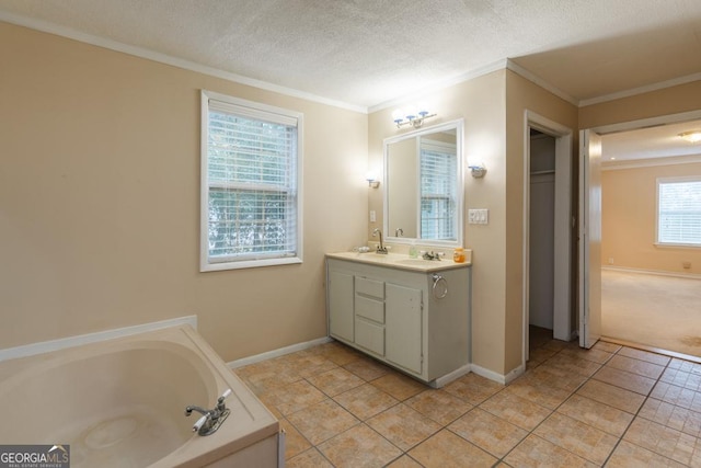 bathroom featuring tile patterned floors, a textured ceiling, a bathtub, vanity, and ornamental molding