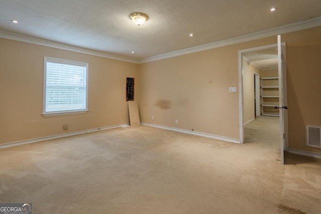 unfurnished room with light carpet, a textured ceiling, and ornamental molding