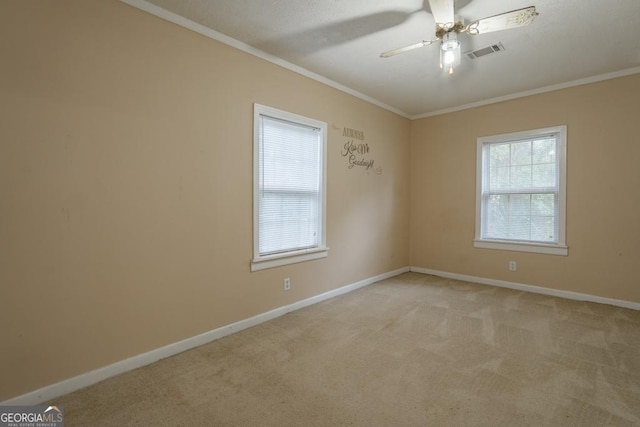 carpeted spare room featuring ceiling fan and crown molding