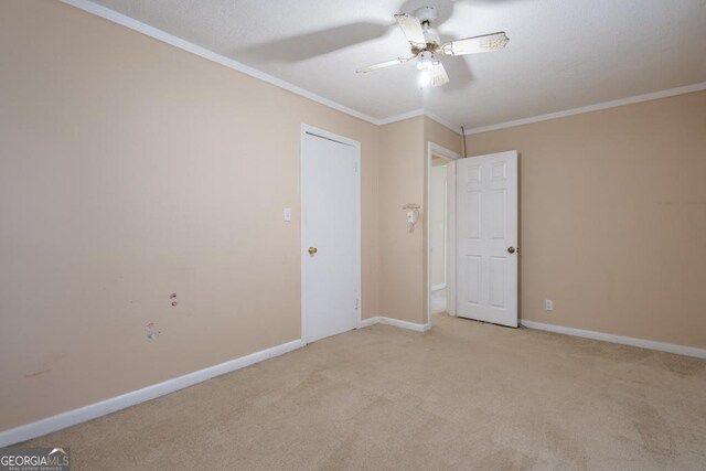 carpeted empty room featuring ceiling fan and ornamental molding