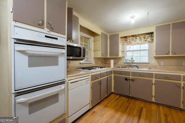 kitchen featuring gray cabinetry, sink, stainless steel appliances, and light hardwood / wood-style floors