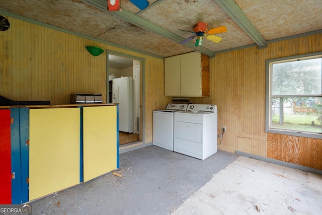 laundry area featuring ceiling fan, wooden walls, and washing machine and clothes dryer