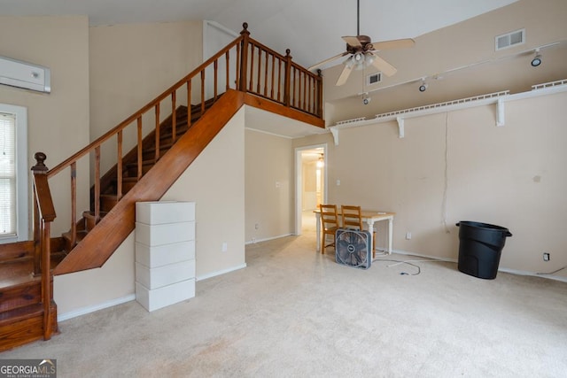 unfurnished living room with ceiling fan, high vaulted ceiling, light carpet, and a wall mounted air conditioner