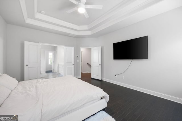 bedroom featuring dark hardwood / wood-style flooring, a raised ceiling, and ceiling fan