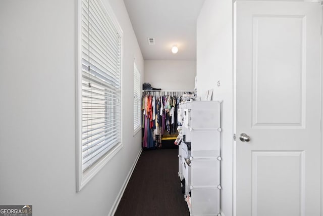 walk in closet with dark hardwood / wood-style flooring