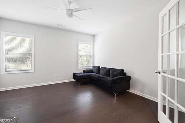 living room with ceiling fan and dark wood-type flooring