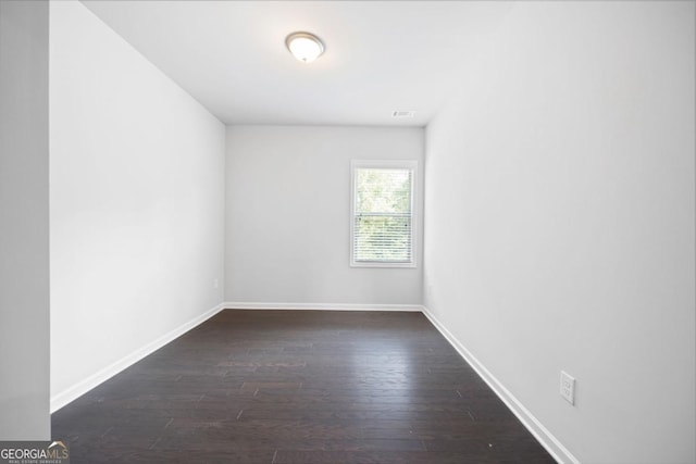 unfurnished room featuring dark wood-type flooring