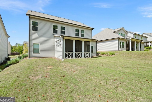 rear view of house featuring a sunroom and a yard