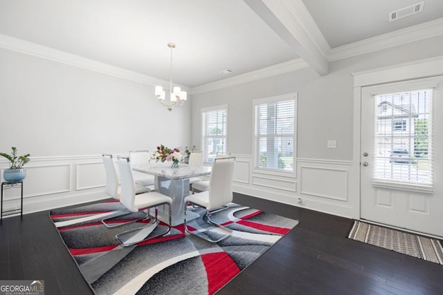 dining room featuring dark hardwood / wood-style floors, a healthy amount of sunlight, ornamental molding, and a chandelier