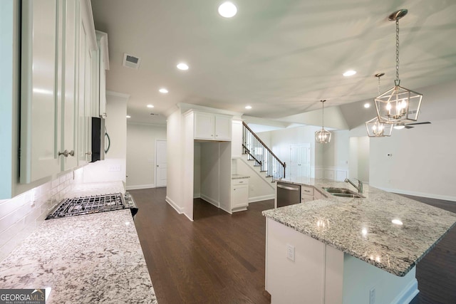 kitchen featuring white cabinetry, hanging light fixtures, stainless steel dishwasher, and sink