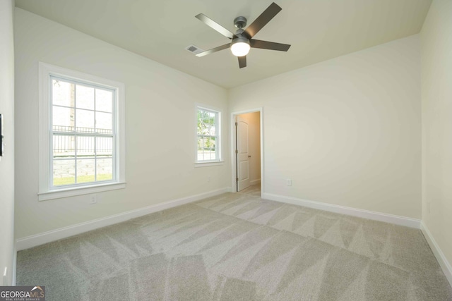 carpeted spare room featuring ceiling fan